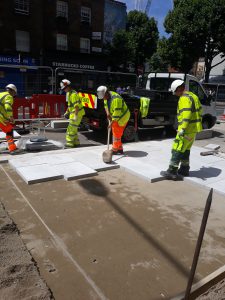Operatives laying new pavement on Tottenham Court Road