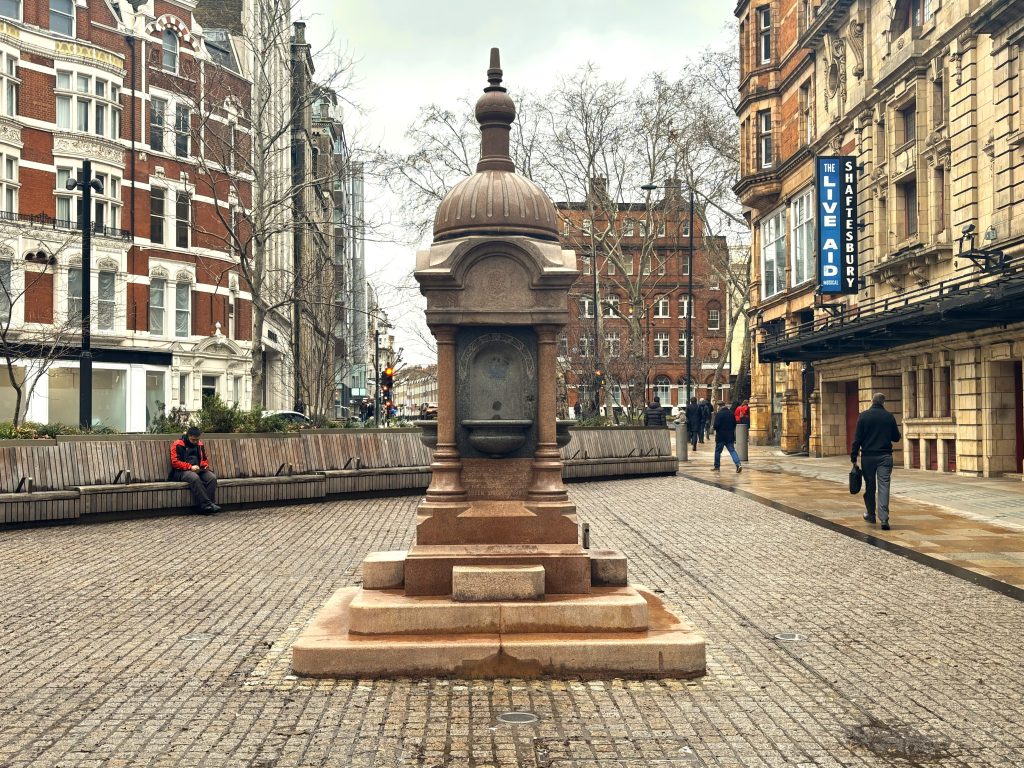 Fountain within the new public space. The fountain is stone with steps to the bowls